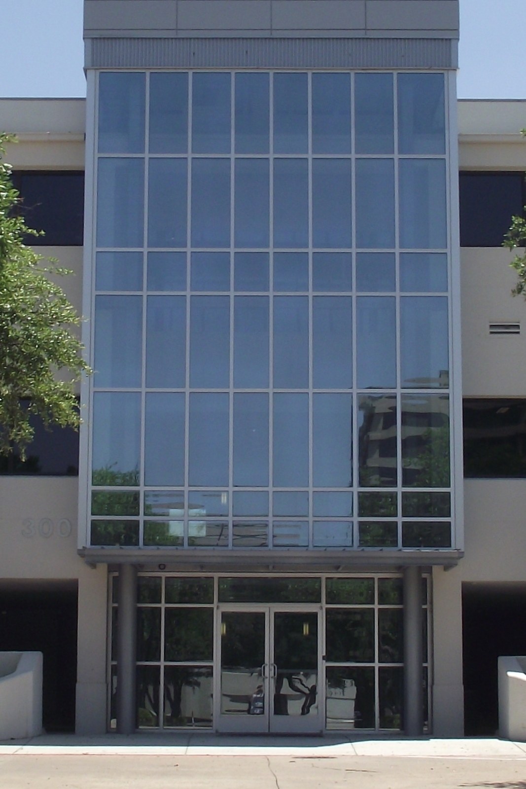Multi-story curtain wall above a commercial glass entrance.